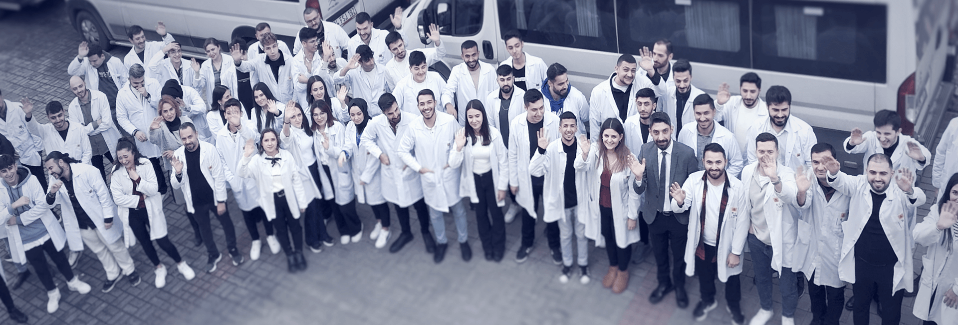 The Remalab team in lab coats before the company delivery vans