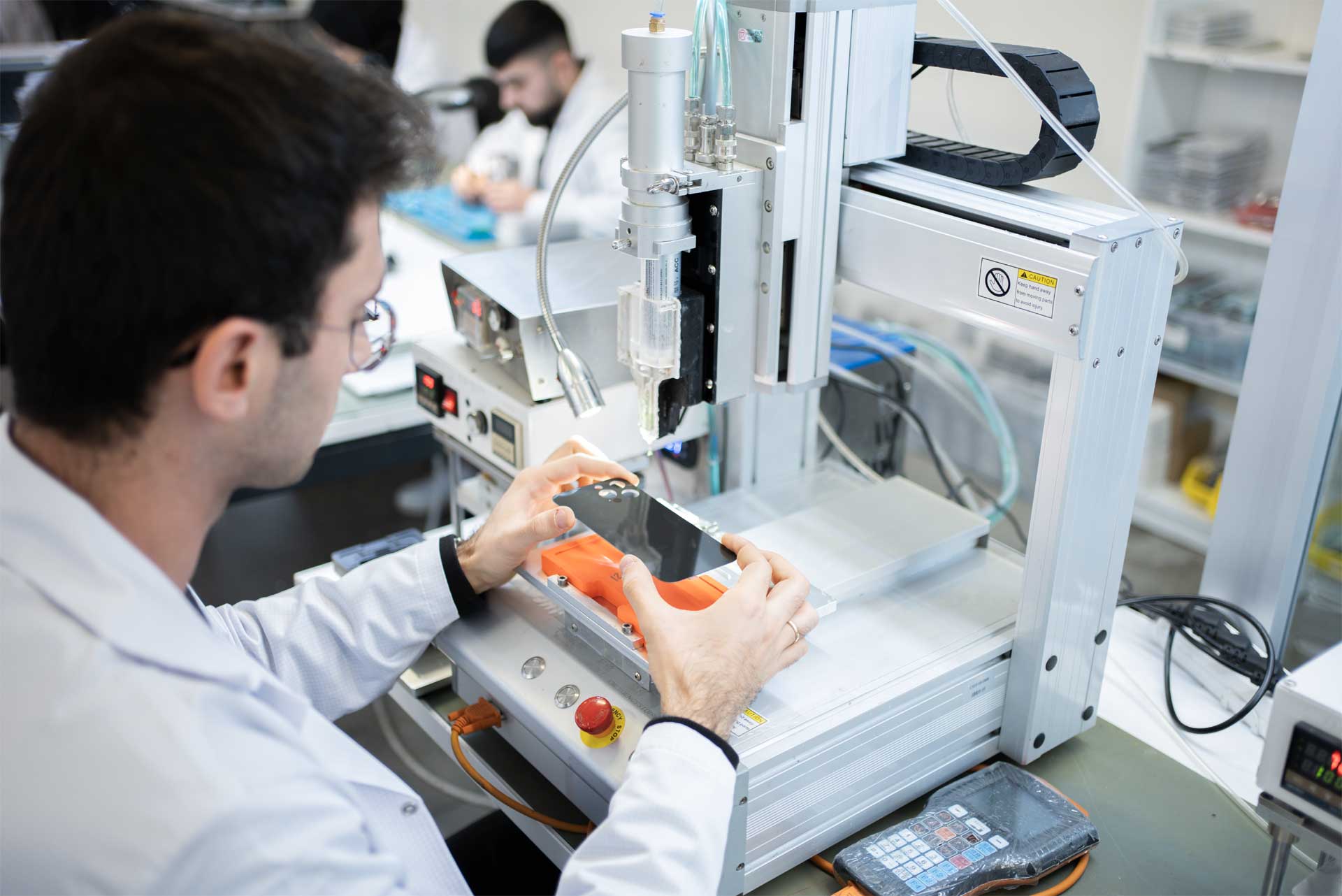 The Remalab precision laboratory with an operator guiding a phone into a machine