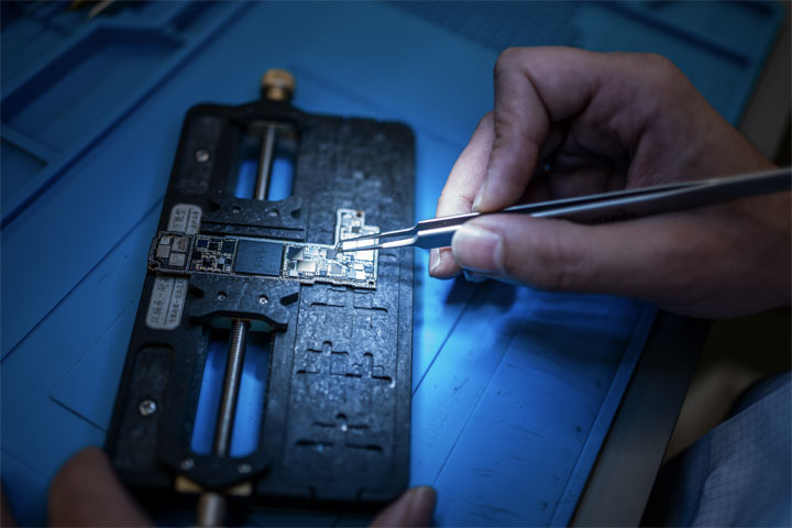 Board-level microsoldering with tweezers on a logic board