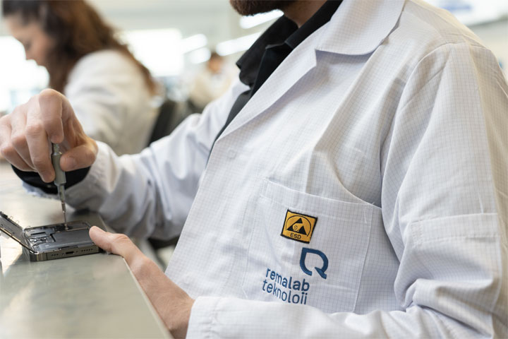 Remalab technician in a branded lab coat disassembling a phone